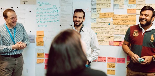 Members of the digital team standing in front of an agile board with post-it notes