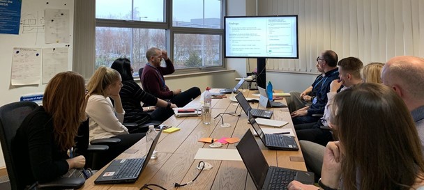 Staff sat around a table looking at a screen